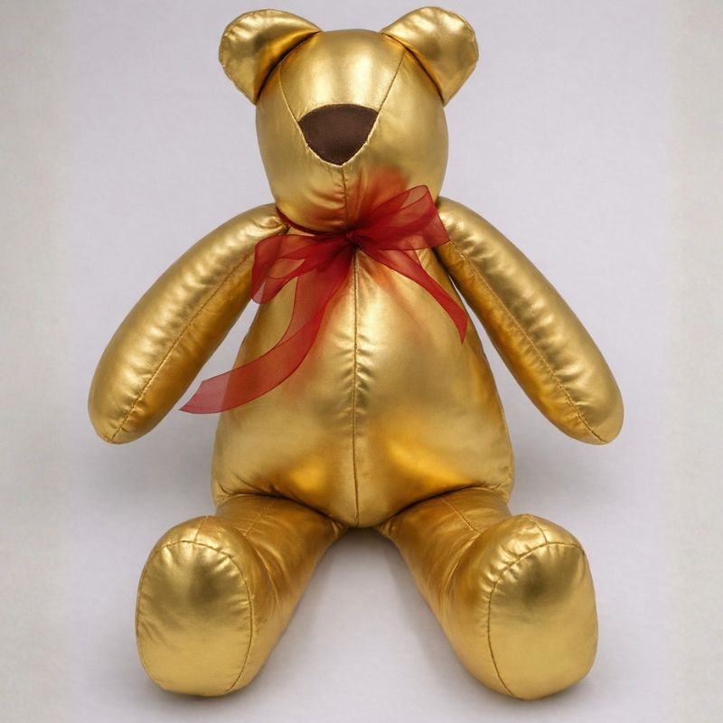 Oso artesanal metálico dorado con listón rojo hecho a mano por La Casa del Oso